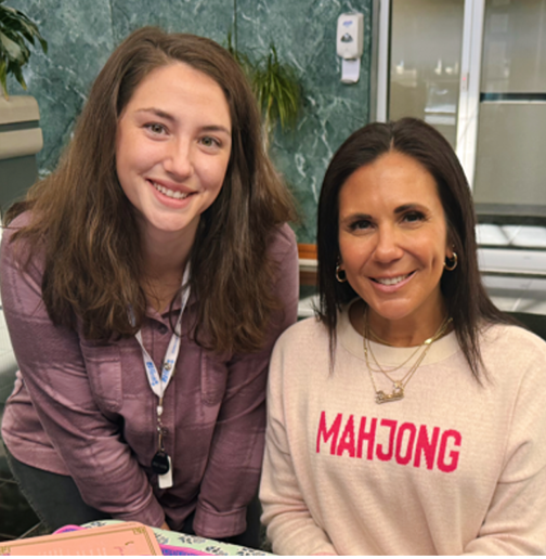 Two women pose behind a mahjong board set up in the LJCC lobby