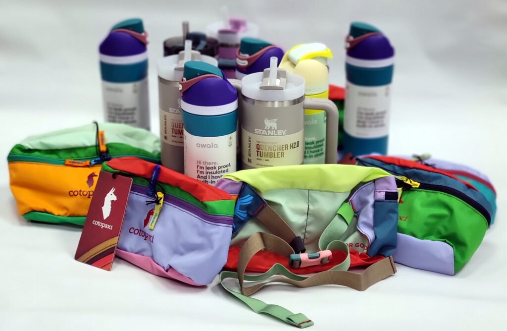 An assortment of colorful hip packs and insulated bottles are posed for display