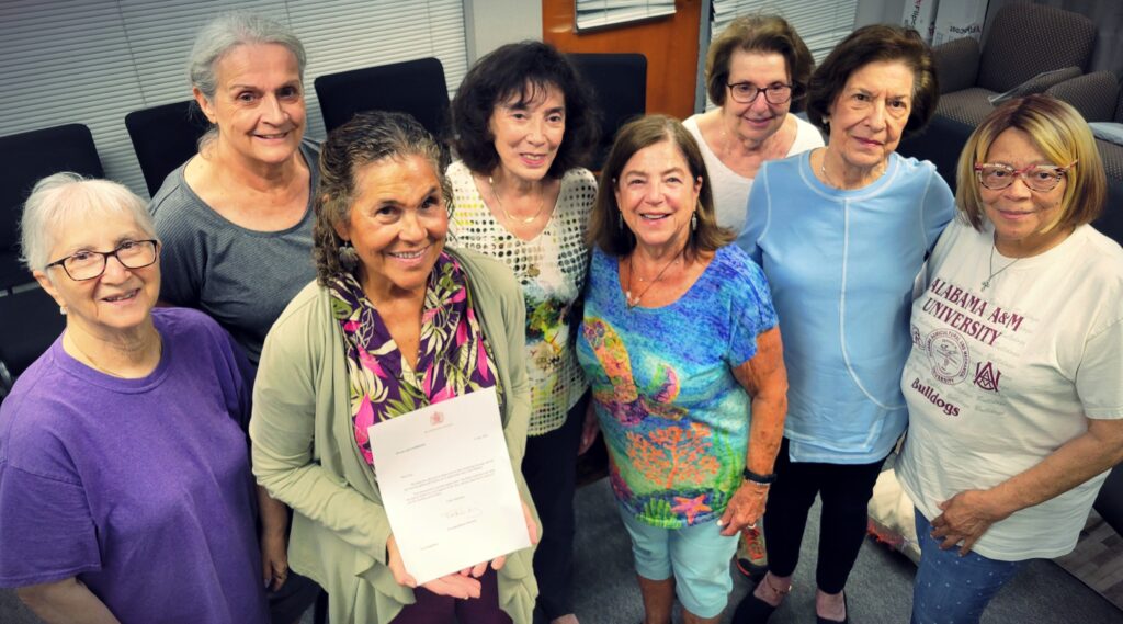 Members of the Roz Feigelson Circle of Life Knitting Group pose with a letter from King Charles of England