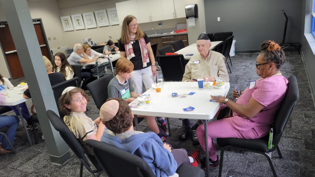 A mix of seniors and students from the N.E. Miles Day School play tabletop games together at The J