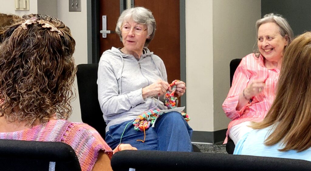 Woman chat while knitting together at The J