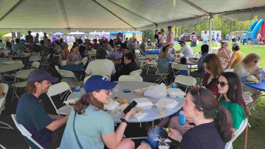 Attendees to the 2024 Jewish Food and Culture Fest enjoy their meal under a large tent