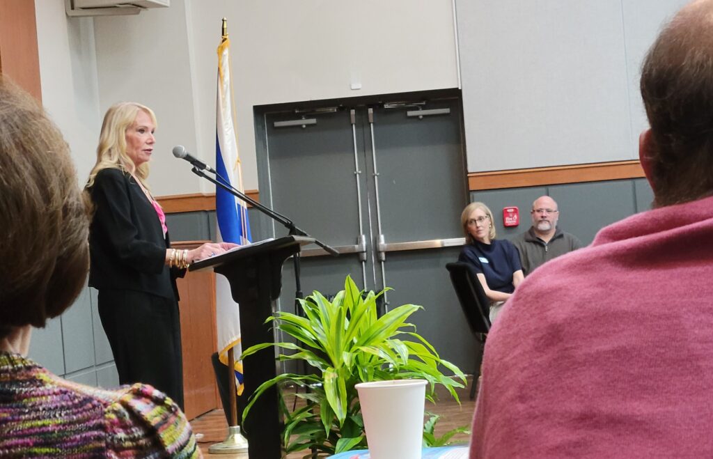 A woman speaks at a podium during the LJCC annual meeting