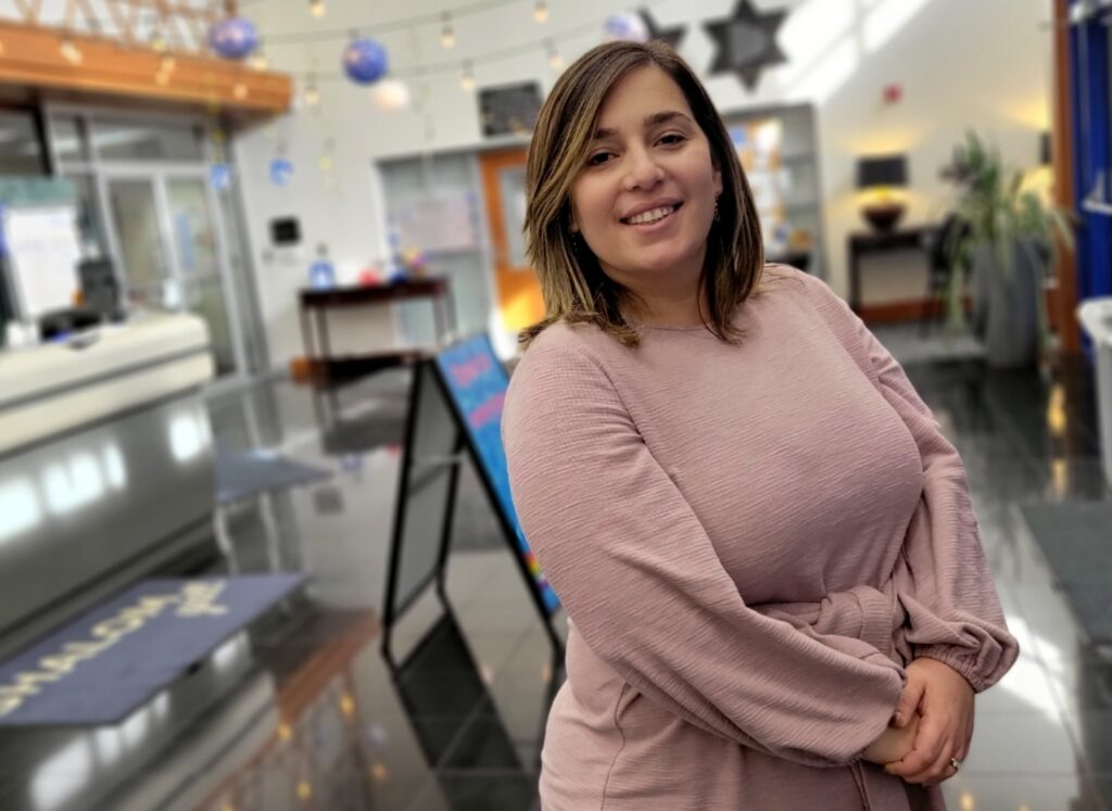 A woman with shoulder-length hair poses in the high-ceilinged lobby of The J