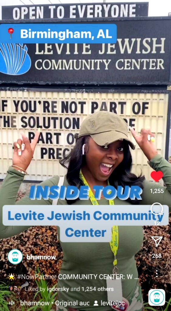 A young woman stands in the parking lot in front of the LJCC marquee