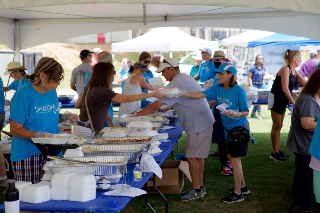 Volunteer servers fill orders under the food tent during Food Fest.