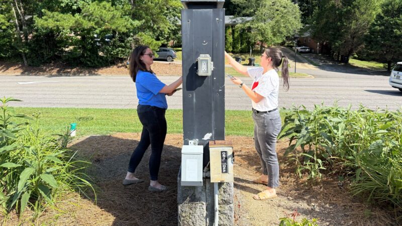 Two women flank the two-sided LJCC marquee as they post new catchy phrases on both sides